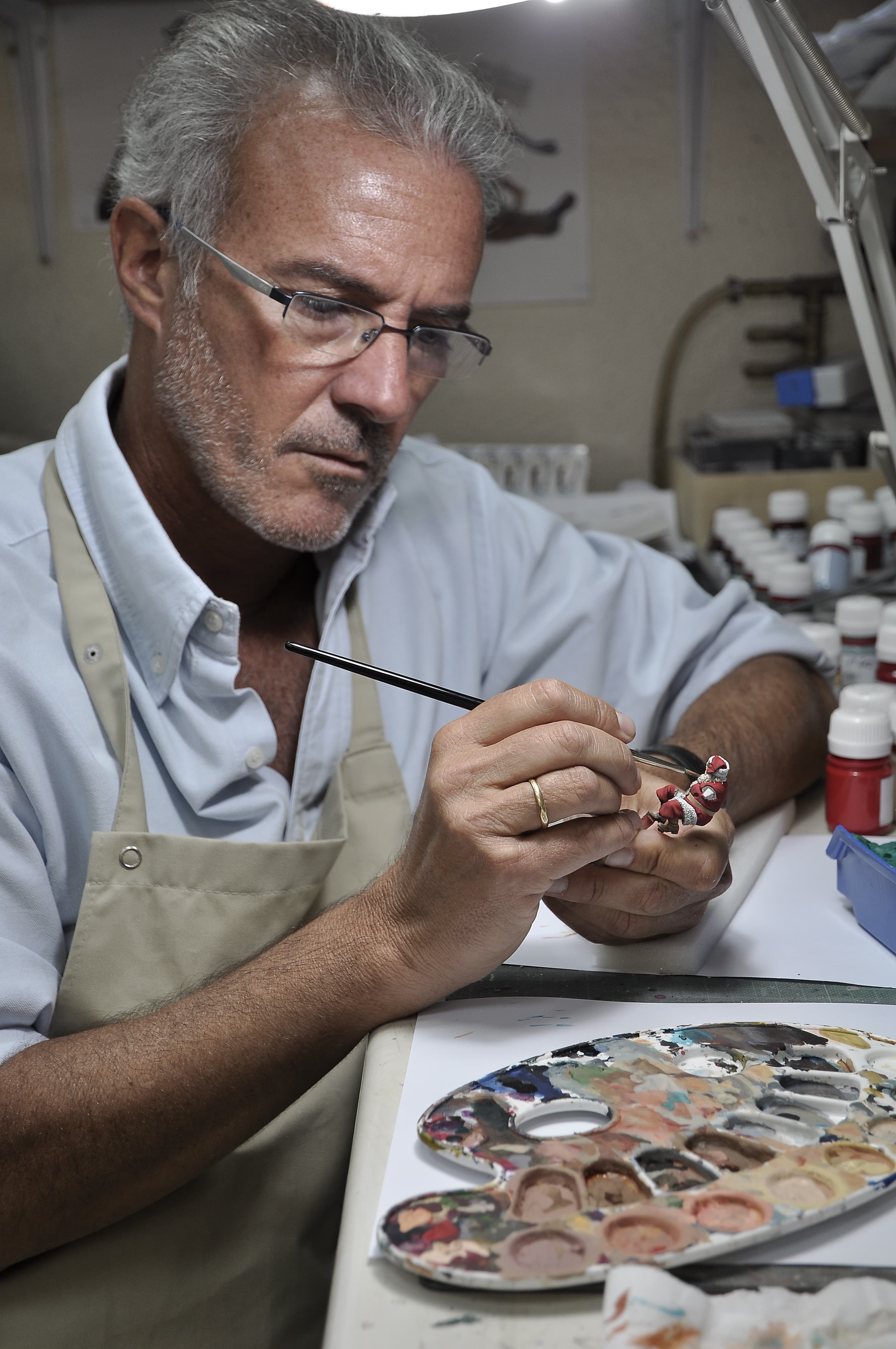 Julio Cabos pintando una miniatura en su mesa de trabajo